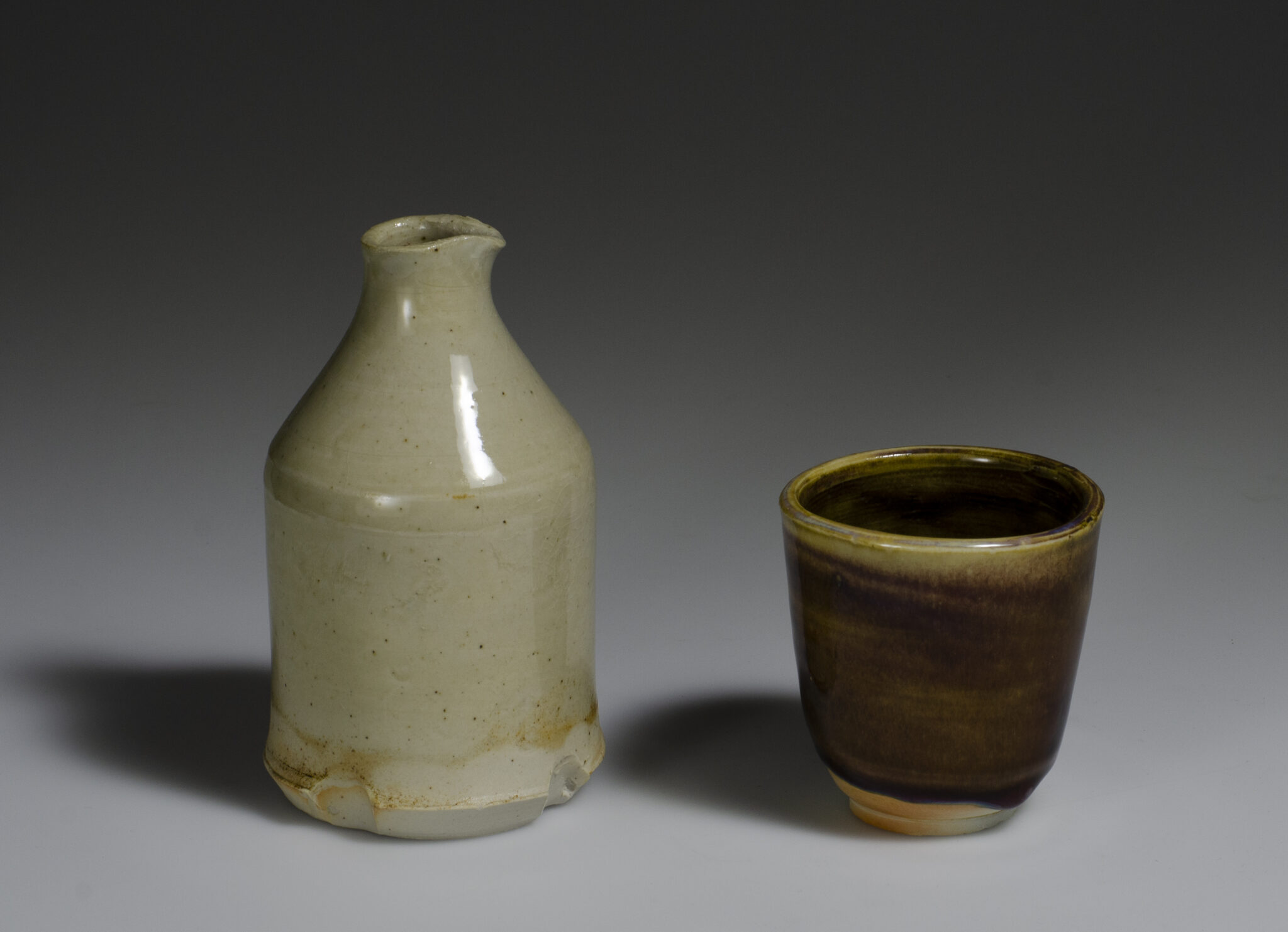 wood fired white porcelain pitcher with pale glaze, tea bowl with with dark auburn glaze